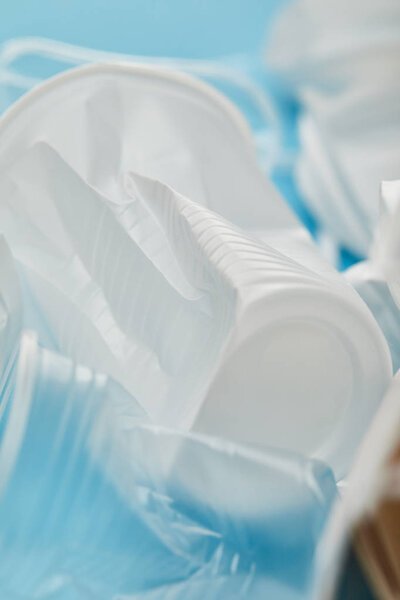 close up view of crumpled plastic rubbish on blue background
