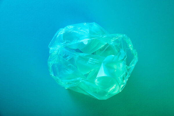 top view of crumpled plastic bag with disposable rubbish in blue light