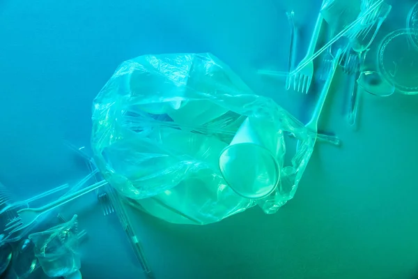 Вид Сверху Скомканный Пластиковый Пакет Чашки Вилки Синем Свете — стоковое фото