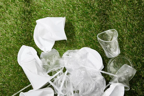 堆皱的塑料袋 杯子和草地上的纸板垃圾的顶视图 — 图库照片