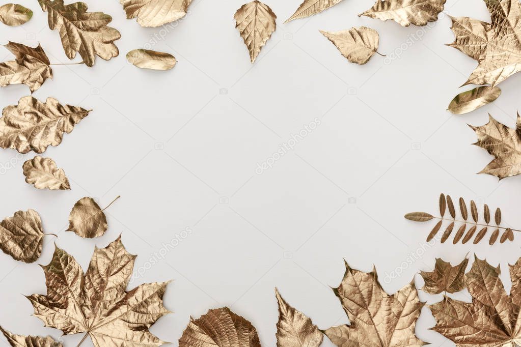 frame of golden foliage on white background with copy space