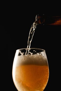 şişeden cam içine akan bira siyah izole