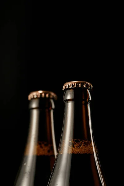 Vista Perto Garrafas Vidro Cerveja Com Tampas Isoladas Preto — Fotografia de Stock