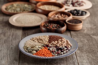 kahverengi masa üzerinde baklagiller ve tahıllar ile ahşap ve seramik tabaklar