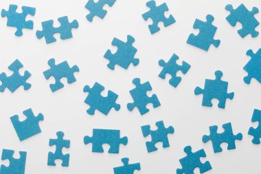 top view of scattered blue jigsaw puzzle on white background clipart