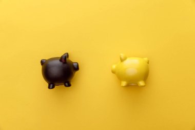 top view of piggy banks on yellow background clipart