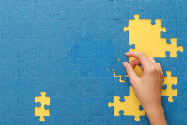 Cropped View Woman Matching Blue Jigsaw Puzzle Yellow Background — Stock Photo, Image