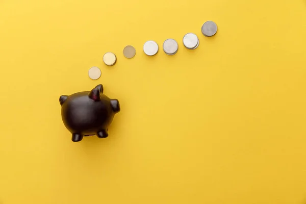 Top Över Black Piggy Bank Med Mynt Gul Bakgrund — Stockfoto