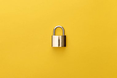 top view of metal padlock on yellow background clipart