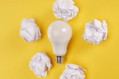 top view of crumpled paper and lamp on yellow background clipart