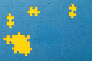top view of blue jigsaw puzzle with yellow gaps clipart