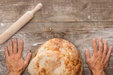 lavaş ekmek ve haddeleme spin ile ahşap masa yakınında adam kırpılmış görünümü