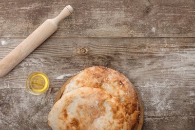 ahşap masa üzerinde zeytinyağı ve oklava fincan yakın lavaş ekmek üst görünümü