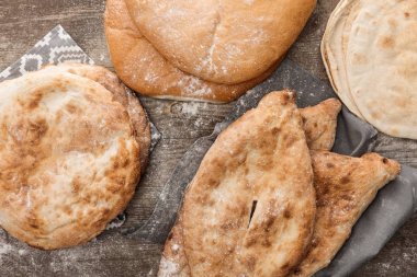 ahşap masa üzerinde çeşitli şekillerde lavaş ekmeği üst görünümü