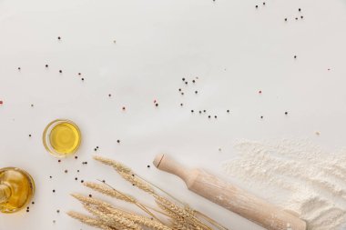 biber ve un ile beyaz yüzeyde buğday başak ve zeytinyağı fincan üst görünümü