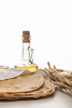 lavash bread covered with white towel near spikes and oil isolated on white clipart