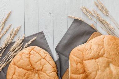 beyaz ahşap yüzeyüzerinde buğday sivri yakın havlu üzerinde lavaş ekmek üst görünümü