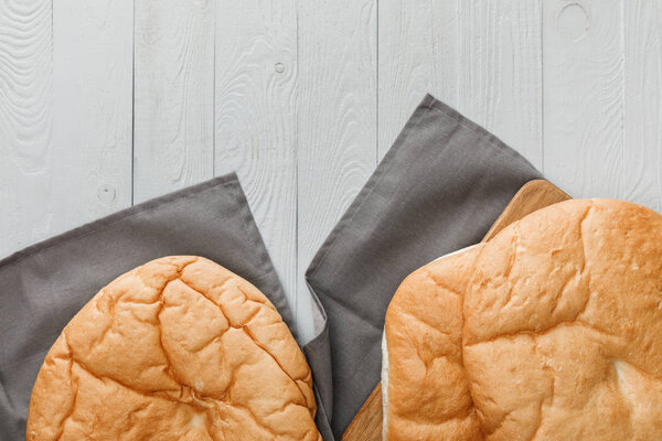 top view of lavash bread on gray towel on white wooden surface