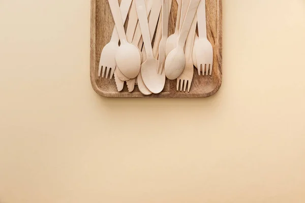 Top View Rectangular Wooden Dish Forks Knifes Spoons Beige Background — Stock Photo, Image