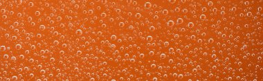 panoramic shot of clear transparent water drops on orange background clipart