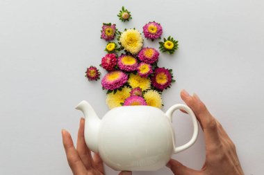Beyaz arka planda elinde çaydanlık tutan bir kadın görüntüsü.
