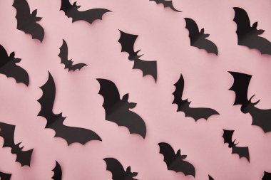 Pembe arka planda kağıt yarasaların üst görünümü, Cadılar Bayramı dekorasyonu