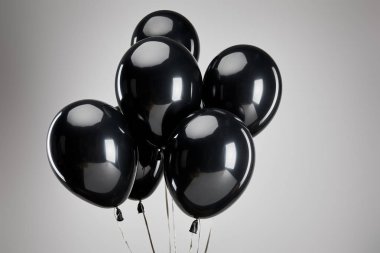 Bir grup siyah balon gri, siyah cuma konseptinde izole edilmiş.