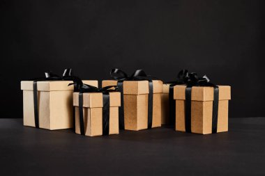 Kara Cuma konseptine izole edilmiş siyah kurdeleli karton hediye kutuları.