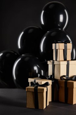 Kara Cuma konseptine izole edilmiş hediye kutularının yanında bir sürü siyah balon.