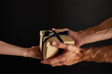 Karton hediye kutusu taşıyan kadın ve erkeğin siyah, siyah cuma konseptine izole edilmiş kurdeleli görüntüsü.