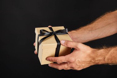 Elinde karton hediye kutusu olan siyah, siyah cuma konseptine izole edilmiş bir adamın görüntüsü.