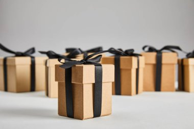 Gri, siyah cuma konseptine izole edilmiş siyah kurdeleli karton hediye kutusunun seçici odağı