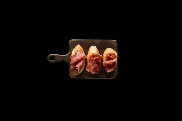 Top View Sliced Prosciutto Baguette Wooden Cutting Board Isolated Black — Stock Photo, Image