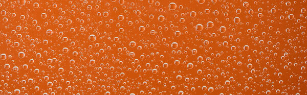 панорамный снимок прозрачных капель воды на оранжевом фоне
