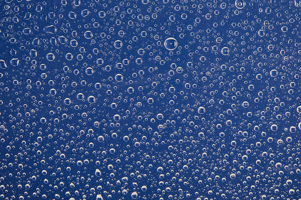clear transparent water drops on blue background