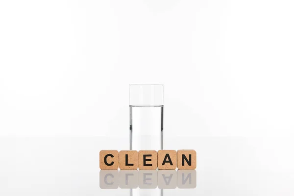 白に隔離されたきれいな文字でキューブの近くのガラスのきれいな新鮮な水 — ストック写真