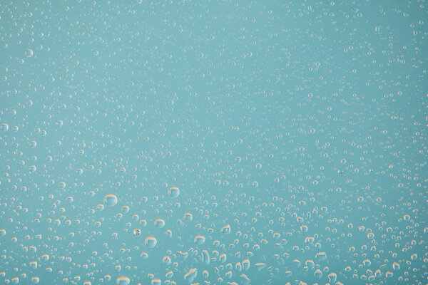clear transparent water drops on light blue background