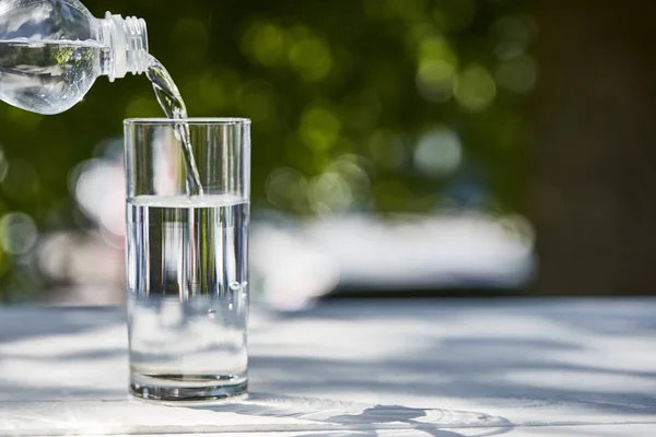 Friss Tiszta Víz Öntés Üvegből Átlátszó Üvegben Napsütéses Napon Asztalon — Stock Fotó