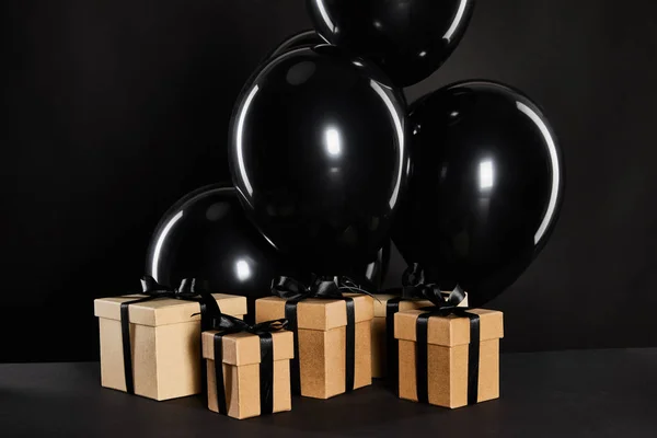 Ένα Μάτσο Μαύρα Μπαλόνια Κοντά Κουτιά Δώρων Που Απομονώνονται Μαύρο — Φωτογραφία Αρχείου
