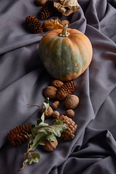 灰色の布に秋の装飾が施された完熟したカボチャ — ストック写真