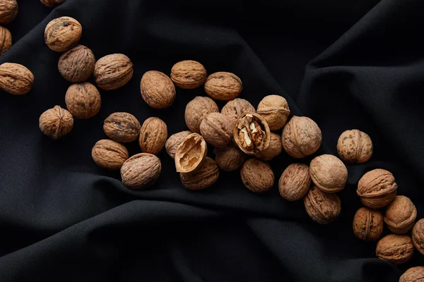 黒い布の上から見た茶色のナッツ — ストック写真