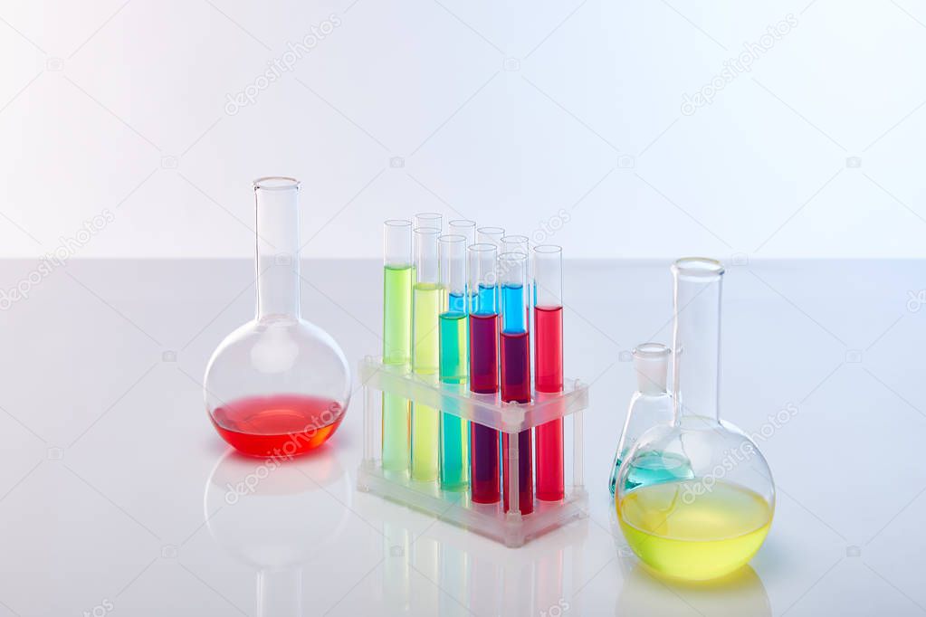 glass test tubes and flasks with colorful liquid isolated on white