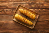 vrchní pohled na chutnou a organickou kukuřici na dřevěné desce 