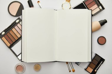Gri üzerine izole edilmiş defter ve dekoratif kozmetik 