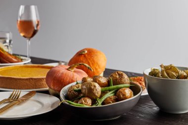 fırında balkabağı ve patates, balkabağı turtası ve gül şarabı ile ahşap masa üzerinde yalıtılmış gri