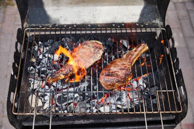 Mangal ızgarasında et ızgarası ve dışarıda kömür parçaları. 