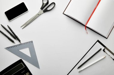 Pano, defter, kalem, makas, üçgen cetvel, hesap makinesi, akıllı telefon üst görünümü 
