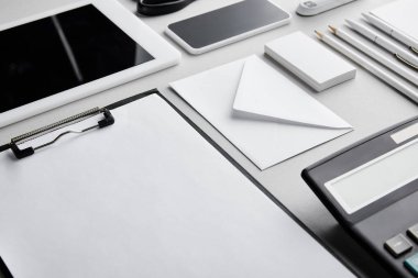 Pano, zarf, kalemler, kalemler, hesap makinesi, kartvizitler, akıllı telefon ve dijital tablet 