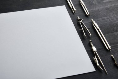 Siyah ve ahşap masa üzerinde pusula ve kopya alanı olan beyaz kağıt 