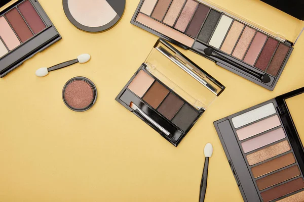 Bovenaanzicht Van Oogschaduw Buurt Van Cosmetische Borstels Geïsoleerd Geel — Stockfoto